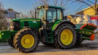 Ciągnik rolniczy John Deere 6830 z rozsiewaczem nawozu